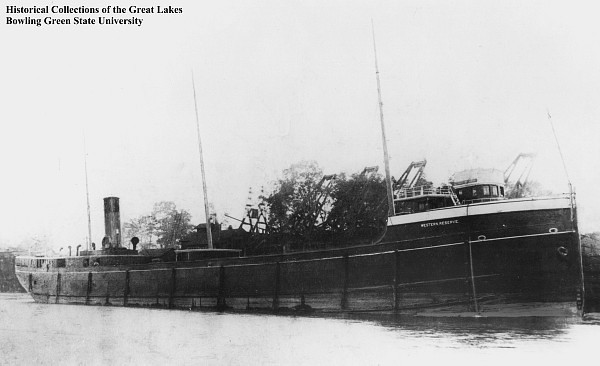 Photo depicts the Western Reserve, a three hundred foot long freighter. The hull and stack are dark.